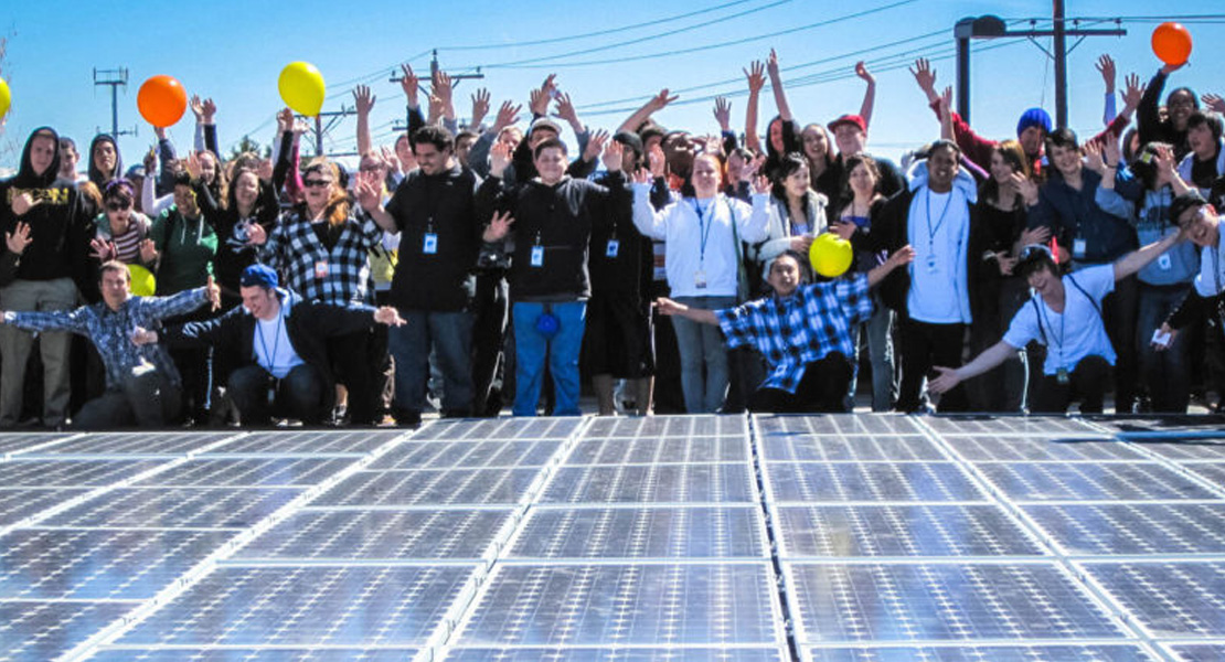 People cheering in front of Solar Panel