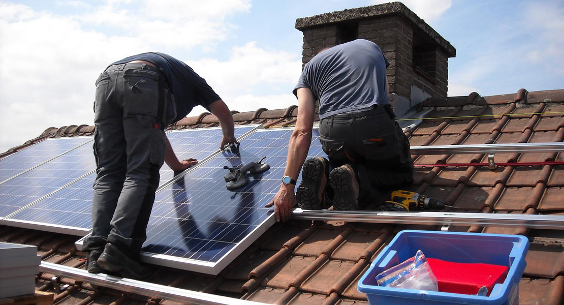 Workers Install the Solar Panel in a Roof